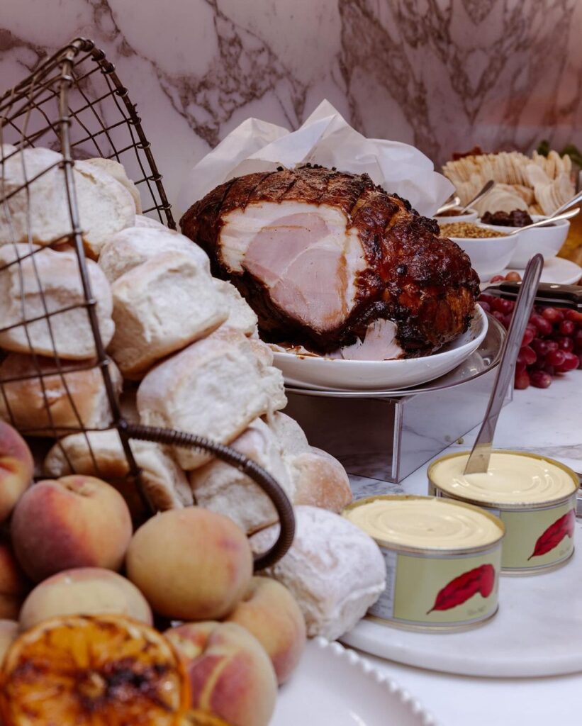 Glazed Christmas Ham which has been sliced and ready to eat with bread rolls and butter, delivered by The Blonde Butler's Christmas catering menu