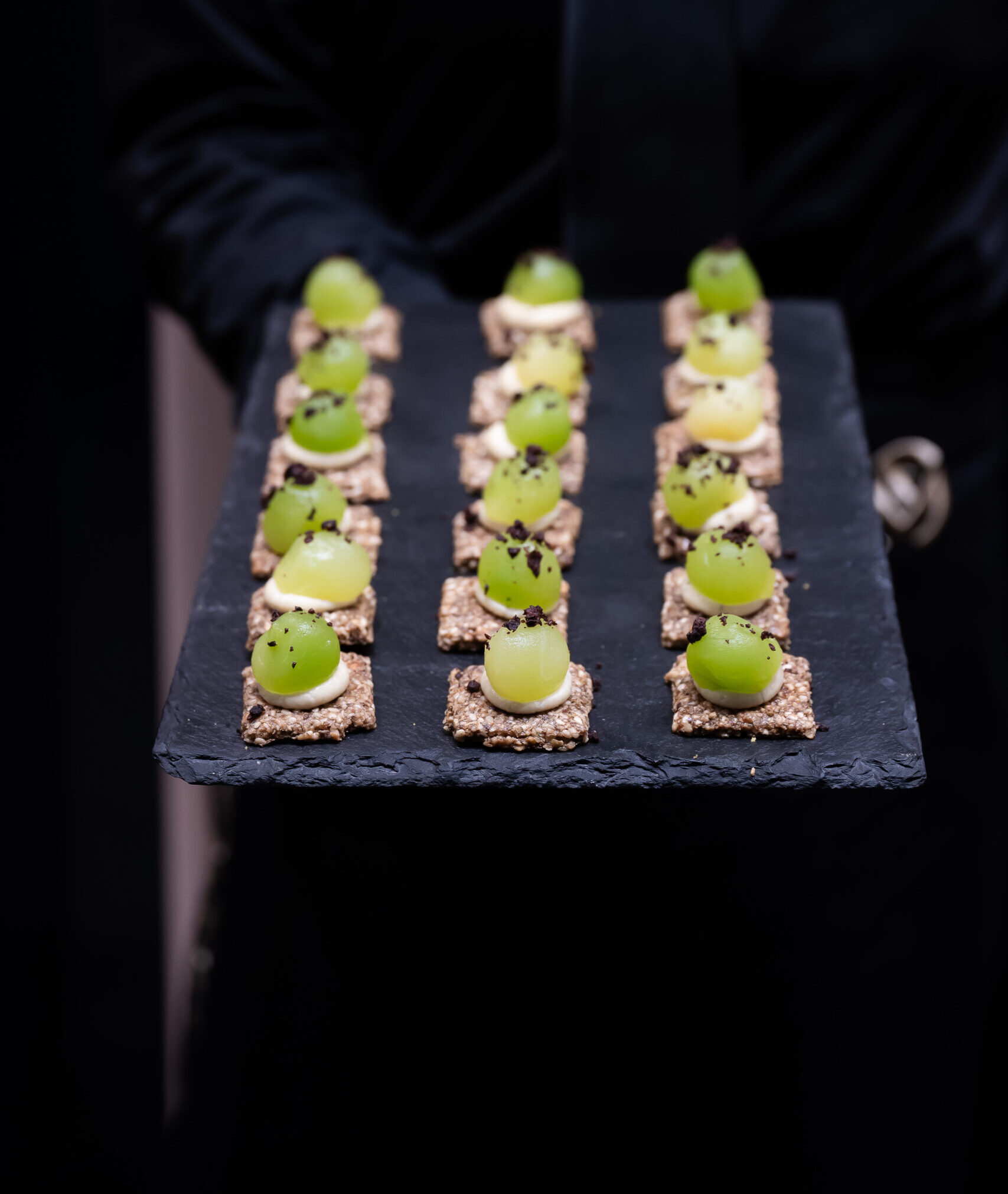 Black platter of elegant bite-sized canapés prepared by The Blonde Butler